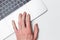 Laptop and hand, top view. The user works on a modern laptop using a trackpad. Modern technology