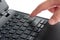 Laptop keypad with index finger pressing enter key