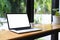 Laptop with lank display and cup of coffee on wooden table.