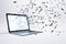 Laptop with multipe particles flow coming out from the glowing white screen on a white background, corner view. Data and