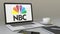 Laptop with National Broadcasting Company NBC logo on the screen. Modern workplace conceptual editorial 3D rendering