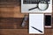 Laptop, Notebook, smartphone, spectacle and magnifying glass on wooden table