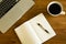 Laptop, notepad and coffee cup on wood table