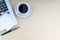 Laptop, notepad, fountain pen and cup of coffee on wooden background