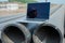 Laptop on pipes at a construction site. Reflection of a portrait of a builder in a helmet on the screen.