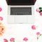 Laptop, roses flowers and candy on white background. Flat lay. Top view. Freelancer office concept
