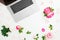 Laptop, roses flowers and petals on white background. Flat lay