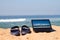 Laptop and sandals on beach