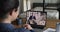 Laptop screen view over businesswoman shoulder distant meeting activity