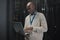 Laptop, server room and black man or technician in data center management, system or cybersecurity. Analysis, serious or