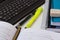 Laptop tablet keyboard, opened textbook with math formula, pencil, stack of school notebooks, highlighter on white desktop