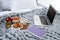 Laptop, tray with breakfast and notebook on bed. Interior