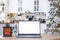 Laptop with a white screen mock up in the cozy white decorated Christmas kitchen with fairy lights and a Christmas tree. Seasonal