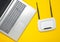 A laptop and a wi-fi router on a yellow paper background. Keyboard, touchpad. Modern digital technologies. Copy space. Top view