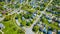 Large aerial neighborhood in summertime with large green trees in city two-story houses