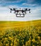 A large agricultural drone sprays rapeseed fields to protect against pests and increase yields.