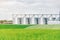 Large agriculture elevator near the field sown with wheat. Modern rural agricultural production