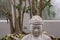 Large Asian Statue Sitting In An Indoor Zen Garden At The Botanical Gardens In Buffalo NY.