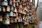 A large assortment of birdhouses, each unique in color and design, mounted on a weathered wall.