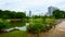 Large and attractive landscape garden in Tokyo. Pond and wooden bridge on the background of modern building