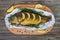 Large baked carp with herbs, lemon and spices in foil on a wooden background.