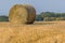 A large bale of hay beside Rutland Water reservoir in summertime