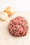 A large ball of minced beef and pork for meatballs and a burger is on the table. Nearby is a round bow.