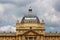 Large baroque style dome on top of old building with metal and glass roof tiles surrounded with various decorative elements