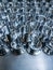 A large batch of shiny metal cnc aerospace parts - close-up with selective focus for industrial manufacturing background