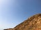 A large beautiful majestic stone sandy mountain, a mound, a hill, a hill in the desert against a blue sky. Landscape