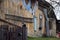 A large beautiful wooden two story abandoned farm house with peeling paint and broken windows in a rural summer