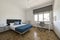 large bedroom with double bed, blue metal nightstands, large window