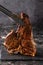 Large beef roast T-bone steak with smoke. Head chef holding steak meat tongs on a black background. copy space