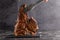 Large beef roast T-bone steak with smoke. Head chef holding steak meat tongs on a black background. copy space