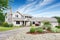 Large beige house with white trim, and well kept lawn