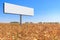 Large billboard stands in the middle of a yellow corn field