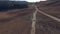 Large black crossover rides along a desert dusty mountain road, around