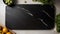 A large black cutting board, possibly with a marbled pattern, placed on a white table