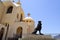 Large black stone lion on the background of an Egyptian orthodox white church with crosses, arches, domes and prayer windows again