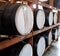 Large black wooden barrels for storage of beverages grouped in a cellar shelf