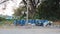 Large blue plastic bins lined up for common litter, outdoor public spaces.