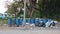Large blue plastic bins lined up for common litter, outdoor public spaces.