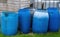 Large blue plastic water butts, tubs to collect rainwater.