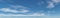 Large blue sky panorama with wispy white clouds