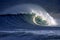 Large blue surfing wave breaking on sand beach