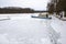 A large boat trapped in ice on a lake. A frozen lake in a boat dock