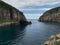 A large body of water next to a rocky cliff