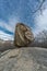 Large boulder of granite rock surounded by trees at Silla de Felipe II Phillip II chair in Guadarrama Mountains