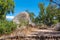 A large boulder sits next to a mountain hiking trail