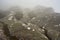 Large boulders covered with moss and lichen spots on foggy morning. Typical scenery during trek to Pic Boby aka Imarivolanitra in